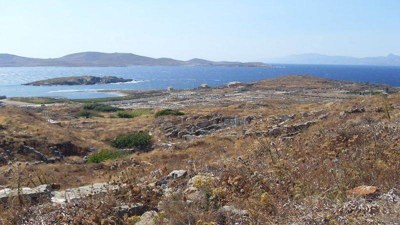 Vy över Delos ruinstad med havet och Kykladernas öar i bakgrunden
