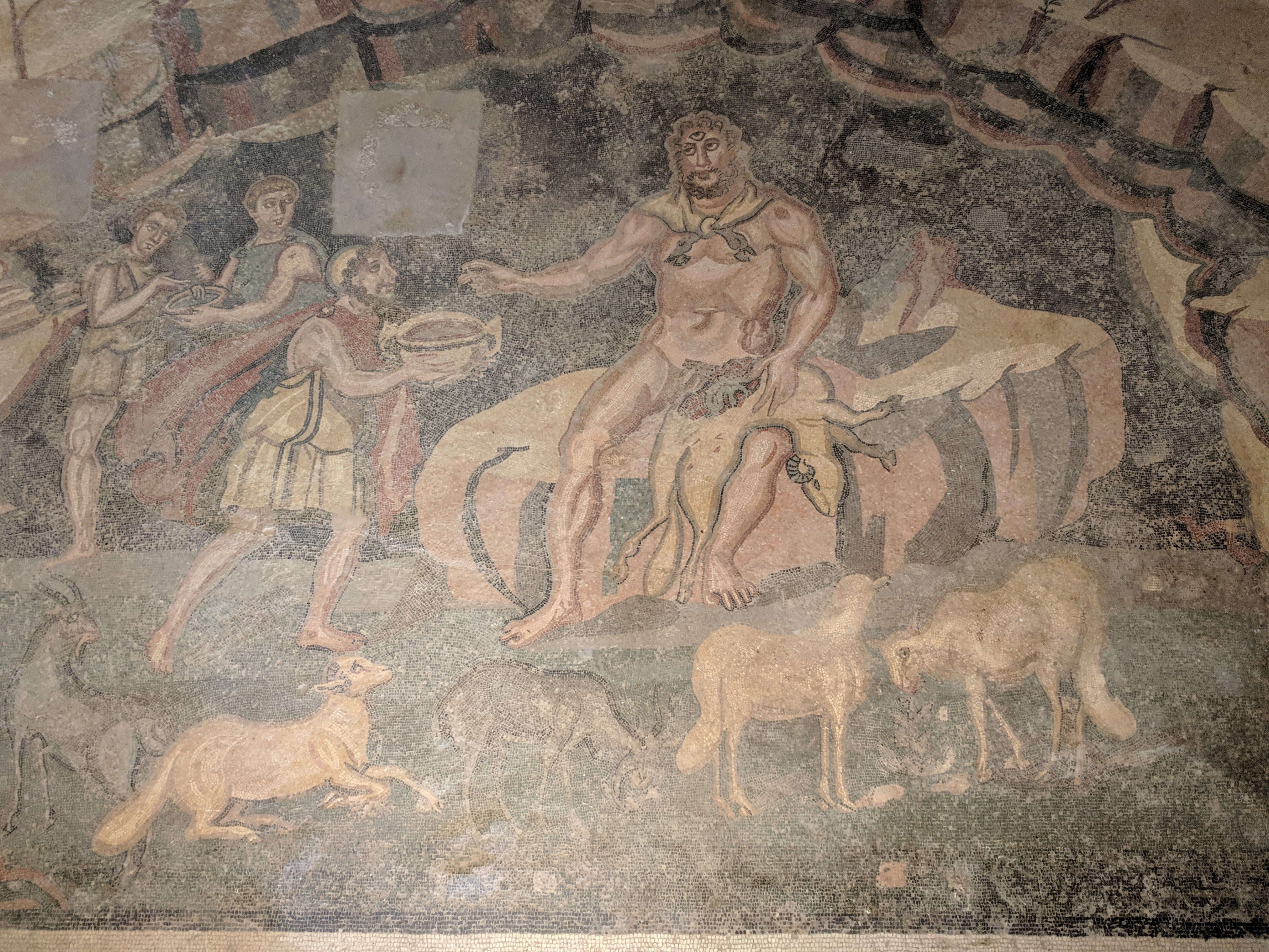 Odysseus räcker vin till cyklopen Polyfemos i en romersk mosaik